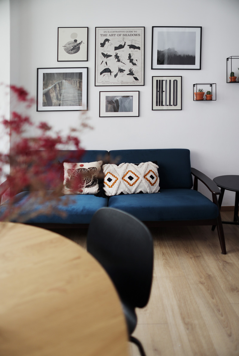 Sofa i ściana z grafikami w strefie relaksu